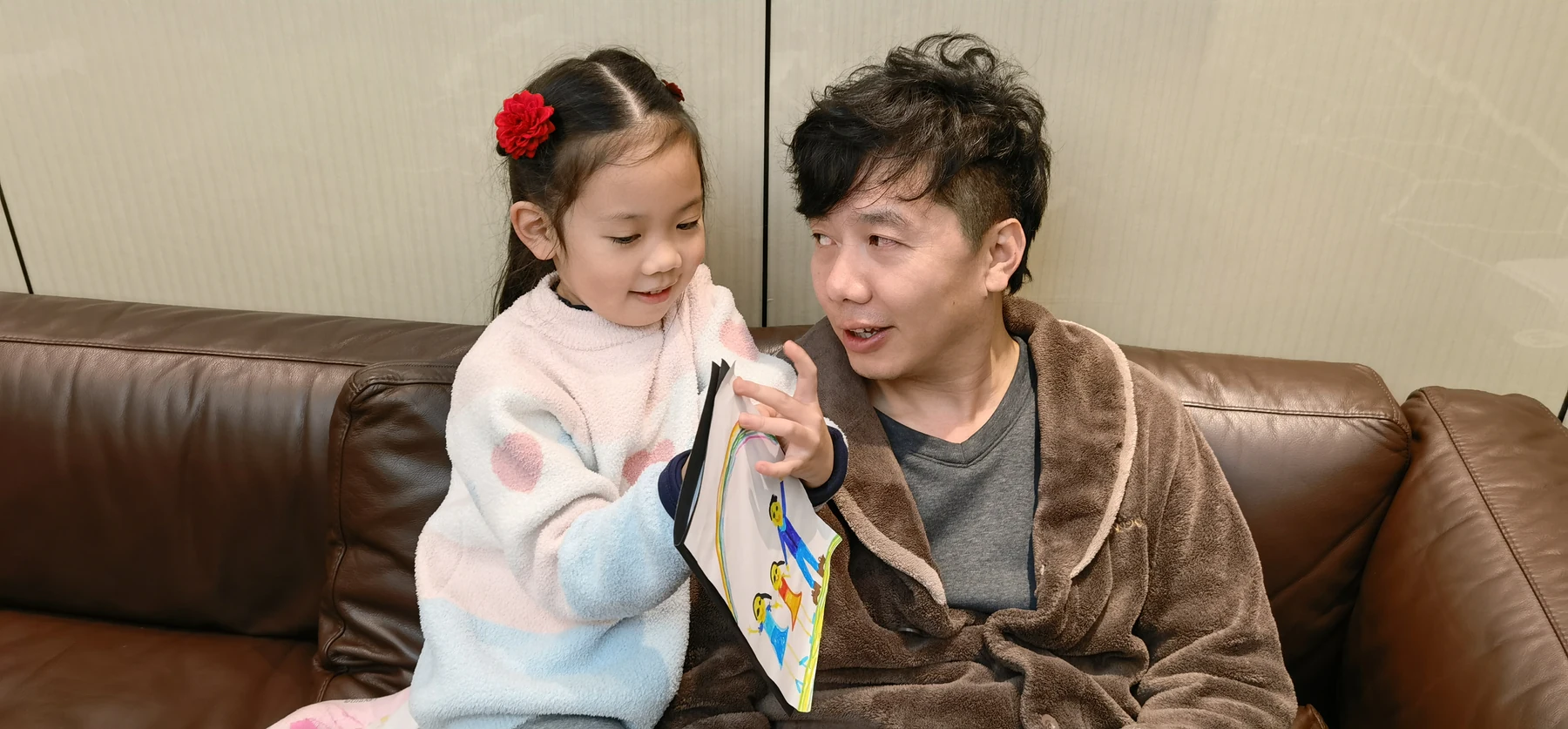 安淇尔和爸爸坐在沙发上交流,爸爸陪伴女儿成长